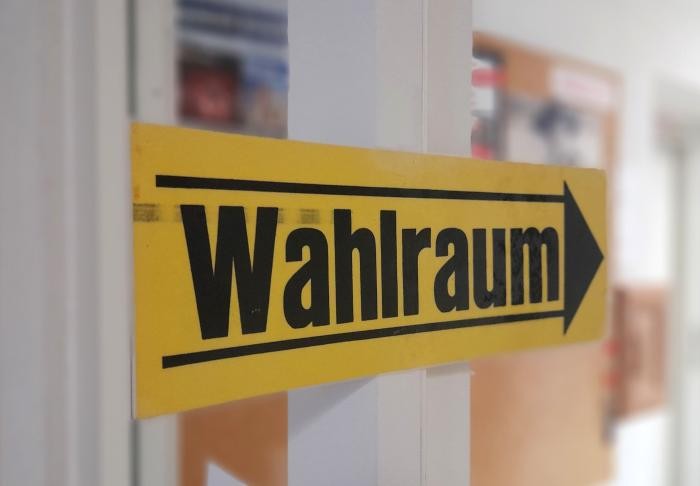 Schild "Wahlraum" Ein schwarzgelbes Schild mit der Aufschrift "Wahlraum" weist den Weg ins Wahllokal