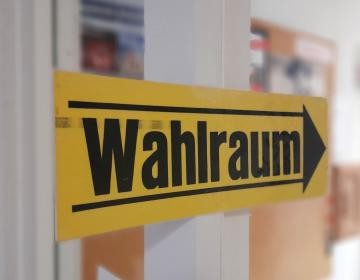 Wahl Ein gelbes Schild weist den Weg zum "Wahlraum"