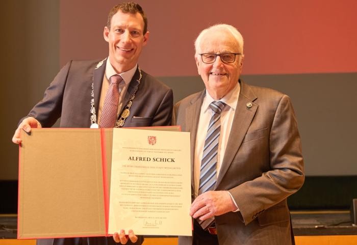 Oberbürgermeister Clemens Moll (links) und der Geehrte Alfred Schick halten die Urkunde.