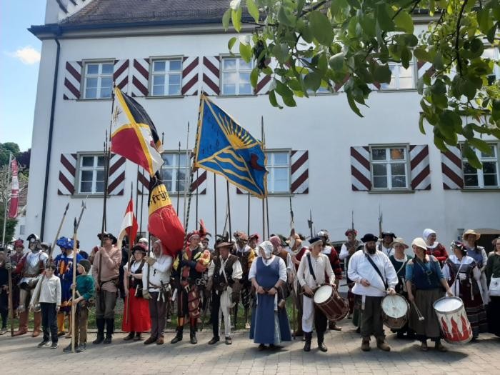 Als Bauern Verkleidete vor einem weißen Gebäude